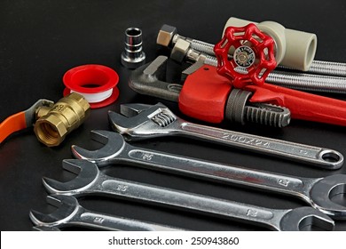 Plumbing Tools On Black Background.