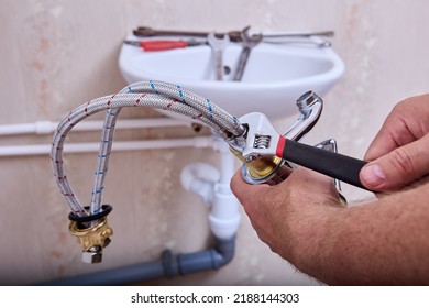Plumbing work in toilet room, plumber installs new water faucet in home piping system. - Shutterstock ID 2188144303