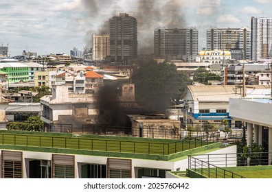 Plume Of Black Smoke Clouds From Burnt Abandoned Building On Fire At Some Area In The Bangkok City. Fire Disaster Accident, Selective Focus.