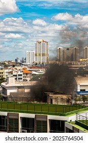 Plume Of Black Smoke Clouds From Burnt Abandoned Building On Fire At Some Area In The Bangkok City. Fire Disaster Accident, Selective Focus.