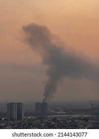 Plume Of Black Smoke Clouds From Burnt Buildings On Fire At Some Area In The Bangkok City In The Evening. Fire Disaster Accident, Selective Focus.