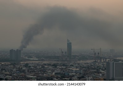 Plume Of Black Smoke Clouds From Burnt Buildings On Fire At Some Area In The Bangkok City In The Evening. Fire Disaster Accident, Selective Focus.