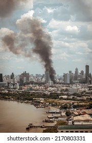 Plume Of Black Smoke Clouds From Burnt Building On Fire At Community Area In The Bangkok City. Fire Disaster Accident, No Focus, Specifically.