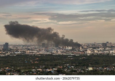 Plume Of Smoke Clouds From Burnt Industrial Or Office Building On Fire At Some Area In The City. Fire Disaster Accident, Selective Focus.