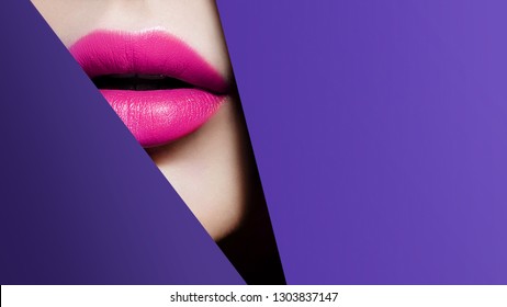 Plump bright pink lips in violet paper frame. Close up beauty photo. Geometry and minimalism. Creative fashion makeup