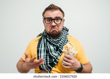 Plump funny man eating tasty shawarma. Glutton