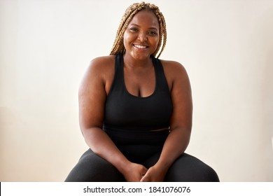 plump, plus size african american young woman in sportswear sit looking at camera, in studio over white background.concept of sport, body positive, equality - Powered by Shutterstock