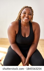 plump, plus size african american young woman in sportswear sit looking at camera, in studio over white background.concept of sport, body positive, equality