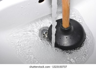 Plunger and clogged sink. Pipe cleaning concept. Sanitary engineering work.