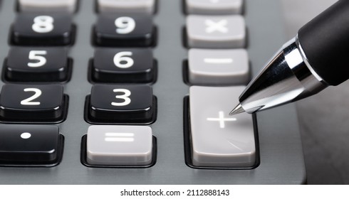 a plus button of the caculator pointed by the black pen. investment concept. asset increased.
