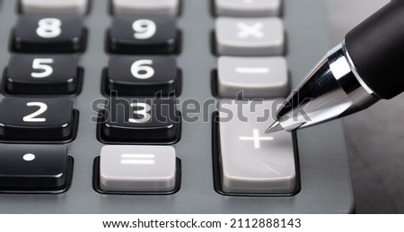 a plus button of the caculator pointed by the black pen. investment concept. asset increased.