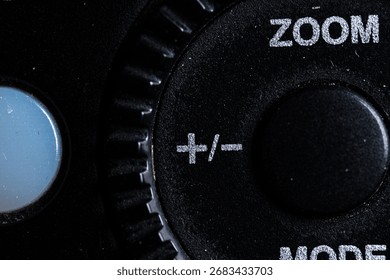 The plus and minus icon button is close on the flash for camera device. Old and dirty