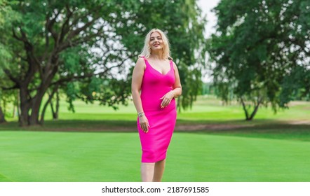 Plus size American blonde woman in pink midi dress at nature. Life of people xl size, happy nice natural beauty woman