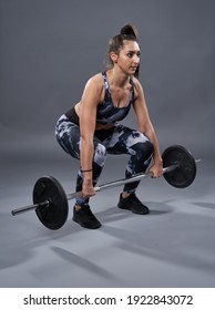 Plus size confident young woman doing barbell deadlift