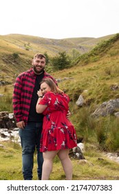 Plus Size Couple Outside On An Adventure Smiling Into The Camera In Front Of A Stream