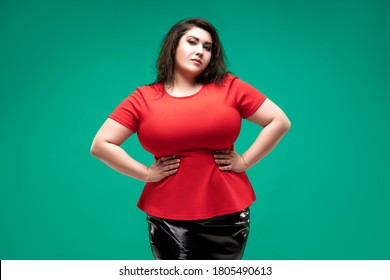 Plus size fashion model in red blouse, fat woman on green studio background, body positive concept