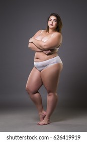 Plus size fashion model in underwear, young fat woman on gray studio background, overweight female body, full length portrait