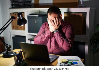 Plus Size Hispanic Man With Beard Working At The Office At Night With Sad Expression Covering Face With Hands While Crying. Depression Concept. 