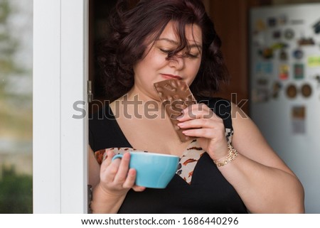 Plus size nice mature woman with chocolate and coffee. Diet and food concept