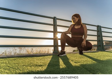 Plus size sportswoman taking break by sea during sunset fitness routine - Powered by Shutterstock