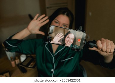 Plus size woman applying makeup on face with brush while recording vlog on smartphone for social media. Multiethnic fashion makeup artist vlogger live streaming makeup tutorial. Part of a series. UGC. - Powered by Shutterstock