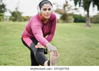 Plus size woman doing stretching after sport workout at city park - Curvy girl and healthy lifestyle concept - Powered by Shutterstock