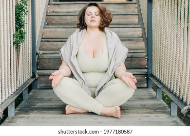  Plus size woman doing yoga and meditation.