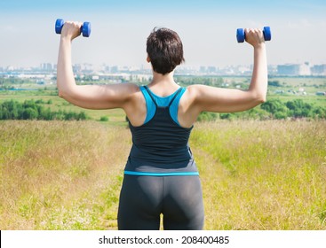 Plus Size Woman Exercising With Dumbbells