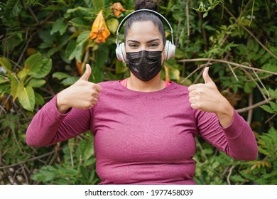 Plus size woman with thumbs up while wearing safety face mask after sport workout outdoor - Curvy person and sport concept - Powered by Shutterstock