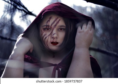 Plus Size Woman Wearing A Red Cape With Claw Marks On Her Face Staring Straight Into The Camera With Red Eyes And Red Lips