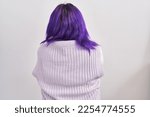 Plus size woman wit purple hair standing over white background standing backwards looking away with crossed arms 