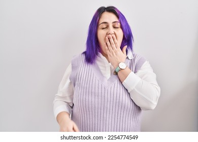 Plus size woman wit purple hair standing over white background bored yawning tired covering mouth with hand. restless and sleepiness.  - Shutterstock ID 2254774549