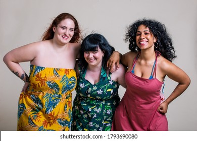 Plus size women making party. Curvy multiethnic girls wearing dresses and having fun