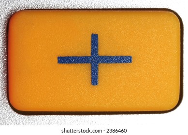 plus symbol on a yellow pressbutton of a pocket calculator