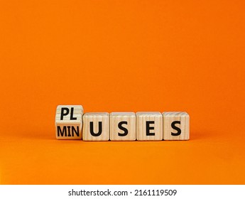 Pluses and minuses symbol. Turned a wooden cube and changed the word 'minuses' to 'pluses'. Beautiful orange table, orange background. Business, pluses and minuses concept, copy space.