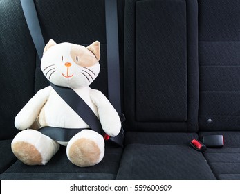 Plush Toy Cat Fastened With Seatbelt In The Back Seat Of A Car, Safety On The Road. Protection Concept.