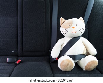 Plush Toy Cat Strapped In With Seat Belt In Back Seat Of Car. Safety On The Road. Protection Concept.