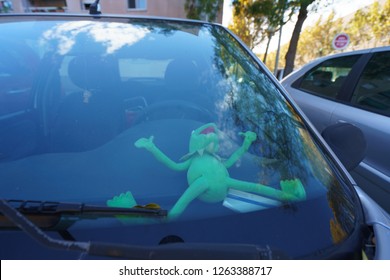 Plush Toy Frog Sleeping Inside The Car. The Driver Is Very Tired.