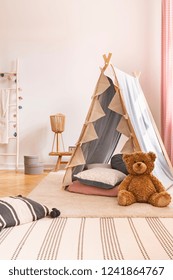 Plush Toy In Front Of Tent In Child's Room Interior With Carpet And Patterned Pillows. Real Photo