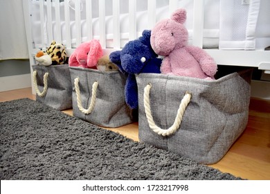 Plush toys stored in baskets under toddler crib in tidy baby bedroom