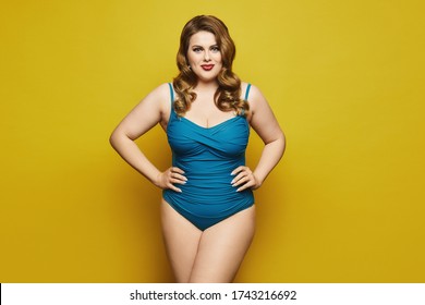 Plus-size model girl with stylish hairstyle and red lips in fashionable swimsuit at the yellow background, isolated. Fat woman in swimsuit on yellow background.
