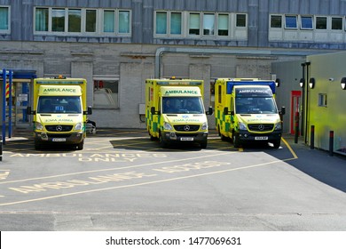 Plymouth England. Three Ambulances Parked In A Hospital Car Par Reception Area.