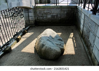 Plymouth, MA, USA, 9.14.21 - The real Plymouth Rock where the pilgrims arrived on the Mayflower ship. It is inscribed with the year 1620 and is enclosed in a memorial with a beautiful beach behind it.