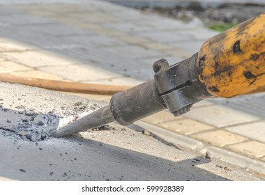 Pneumatic hammer cutting asphalt at construction site.Close up shoot