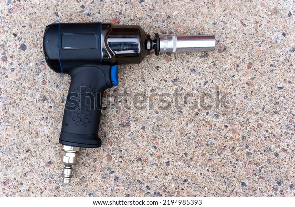 a pneumatic impact wrench with an end head on the
concrete floor