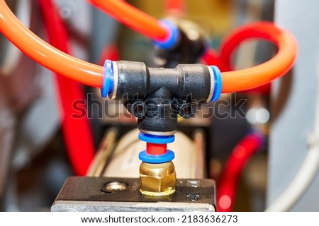 pneumatic system tubes connected to the tee and pneumatic cylinders