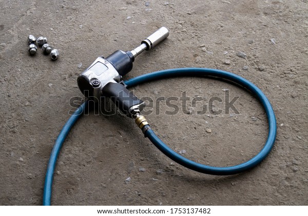 Pneumatic wrench or backyard
mechanics impact wrench for replacement tires is laying on the
ground.
