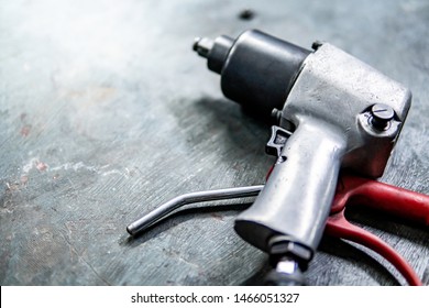 Pneumatic Wrench On Concrete Floor In Auto Repair Shop. Car Wheel Repairing Concept