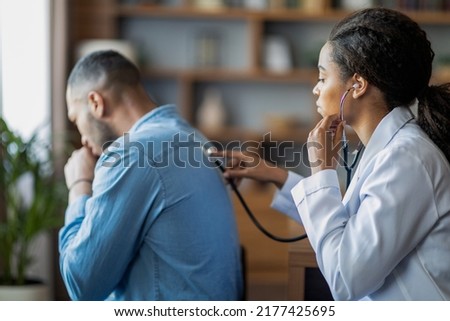 Pneumonia, bronchitis, coronavirus, lungs diseases concepts. Black woman general practitioner checking sick man lungs with stethoscope, ill patient coughing while having checkup with doctor, side view