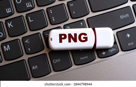 PNG (Portable Network Graphics) - the word on a white flash drive, lying on a black laptop keyboard